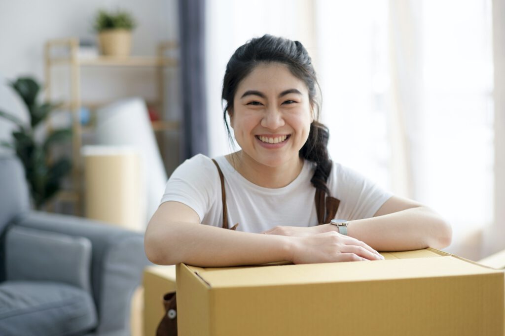 Happy woman smiling at home during move with boxes